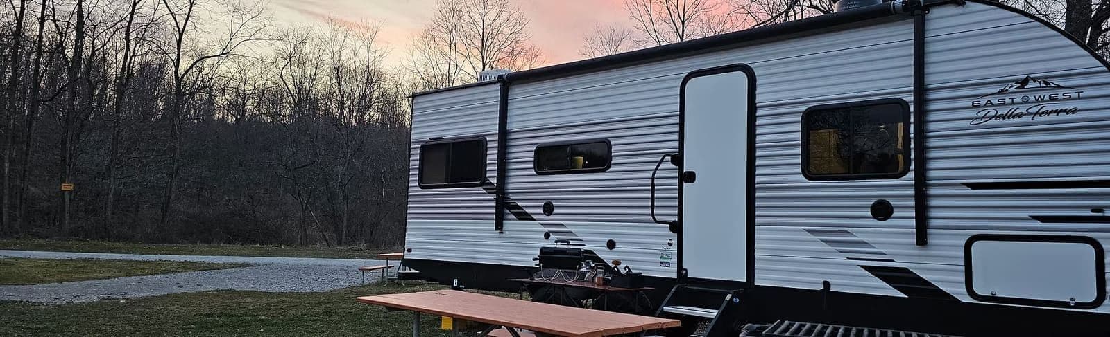 Wanderous travel trailer parked at a campsite at sunset